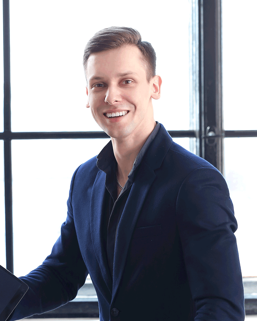 A man in a suit smiling for the camera.