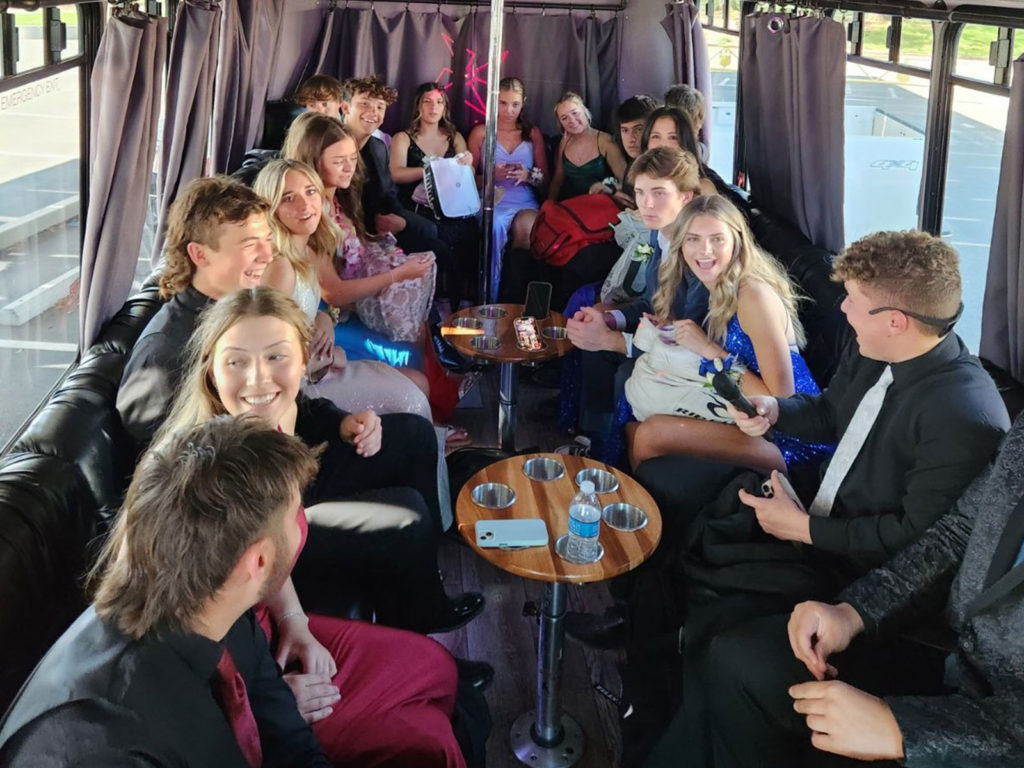 A group of people sitting on top of a bus.