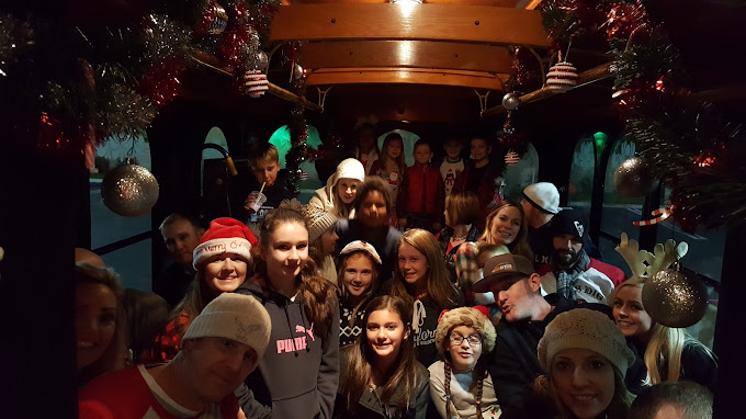 A group of people standing in front of christmas decorations.