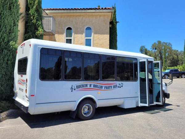 A white bus parked in front of a building.