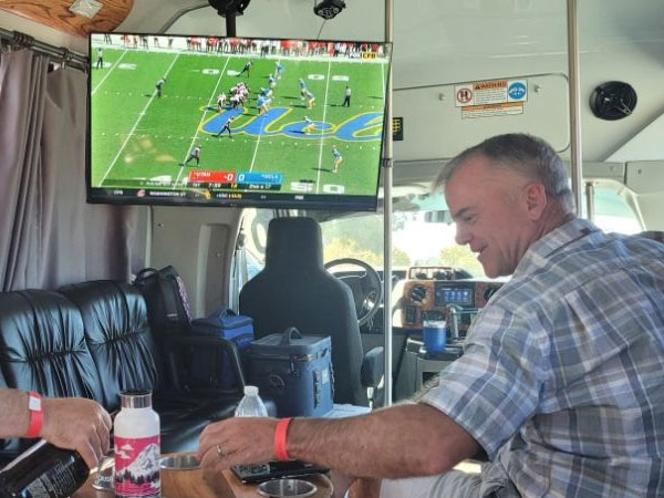 A man sitting at the table in front of a tv.