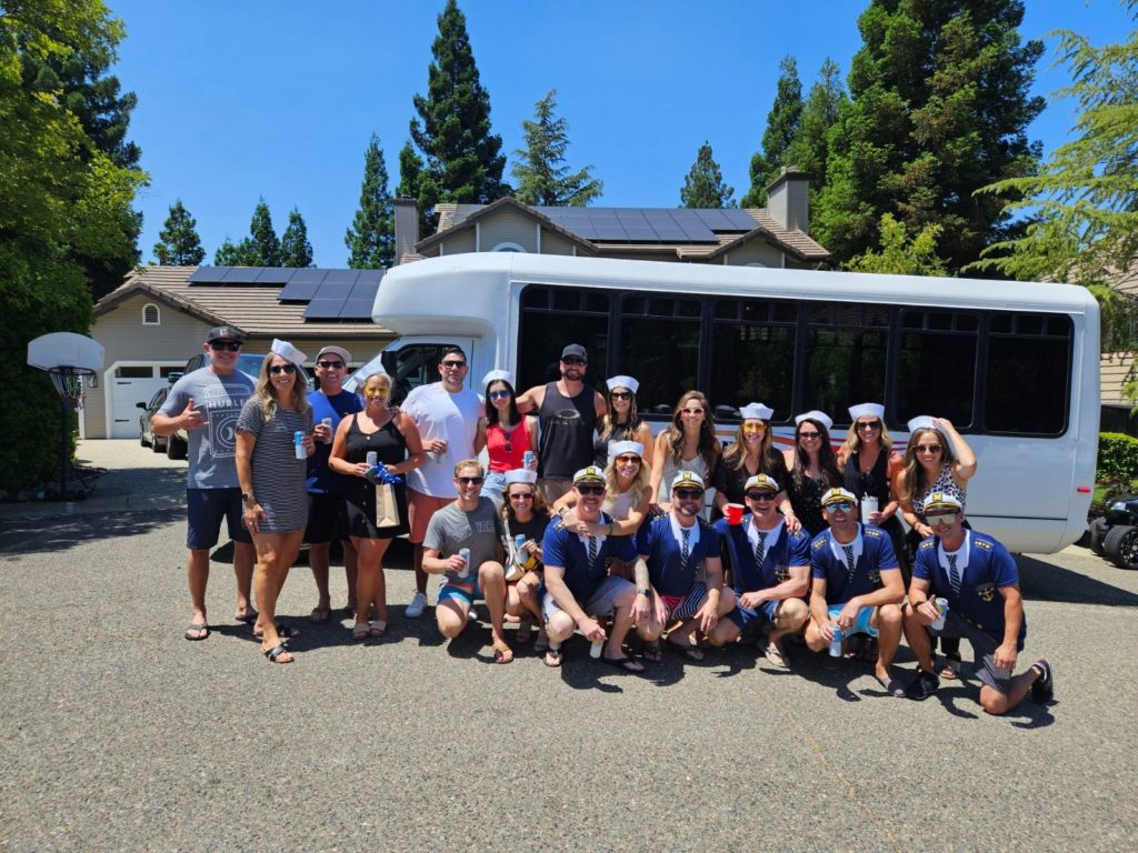 A group of people posing for a picture in front of a bus.