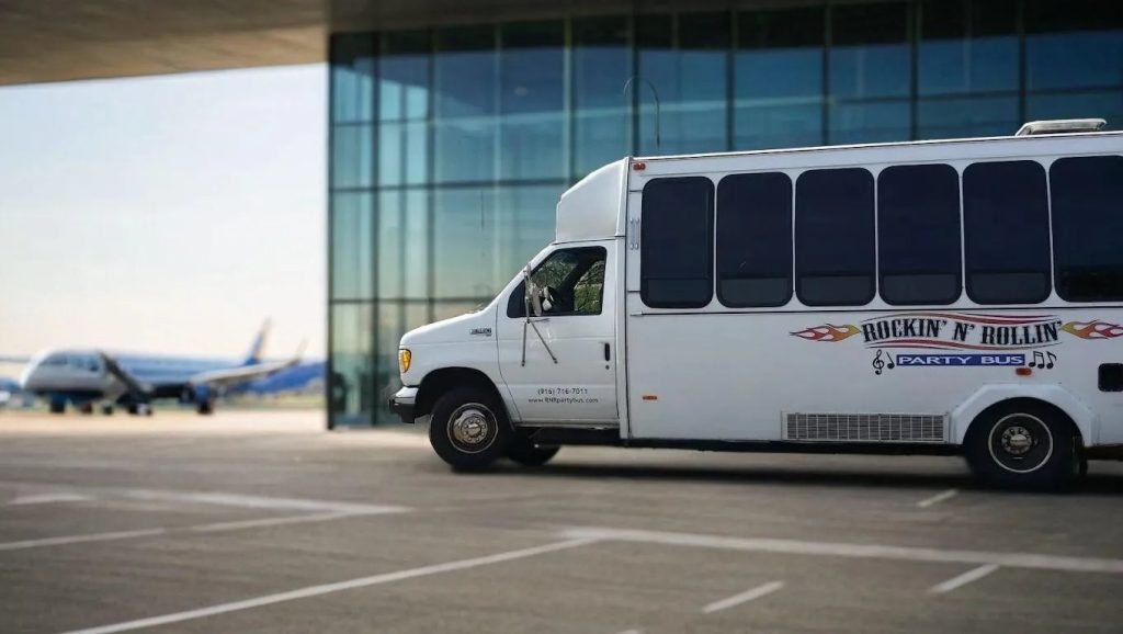 A white bus parked in front of an airport.