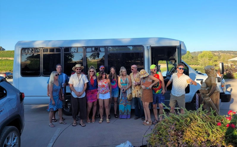 A group of people standing in front of a bus.