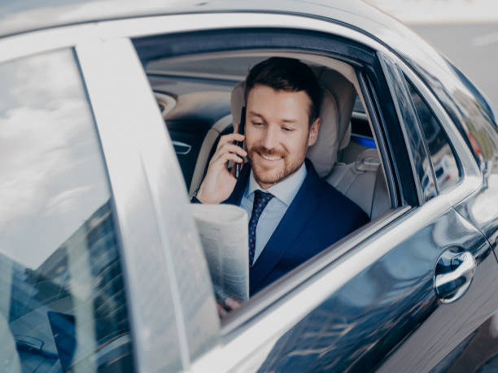 A man in a car talking on the phone